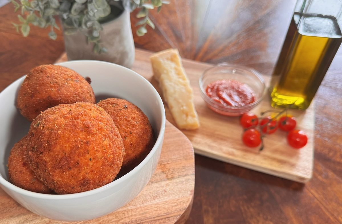 Bowl of arancini with parmesan, tomatoes, and marinara