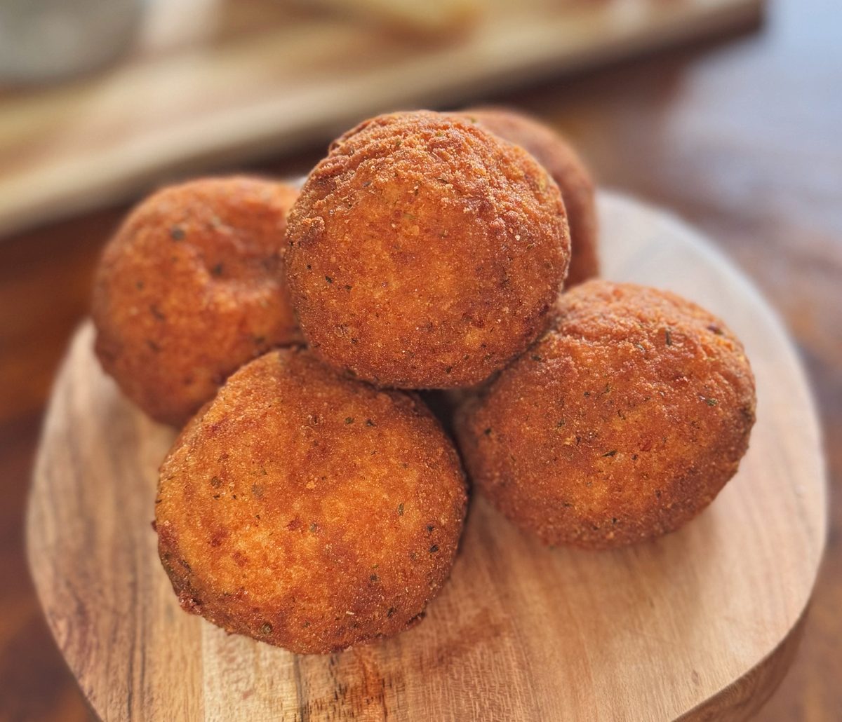 A pile of arancini on a wood board
